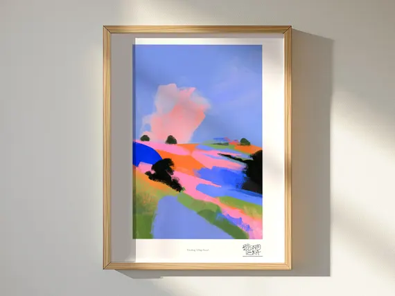 Winding Village Road framed art print, shown hanging in a styled room